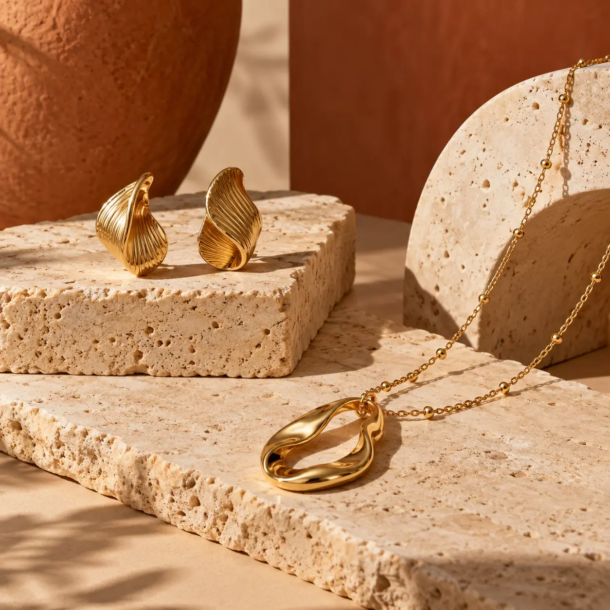 Gold jewellery on warm stone